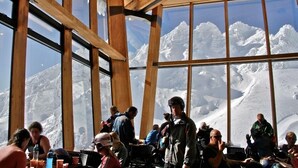 A dining area with large windows offering mountain views. - Parkview Apartments (National Park Village)