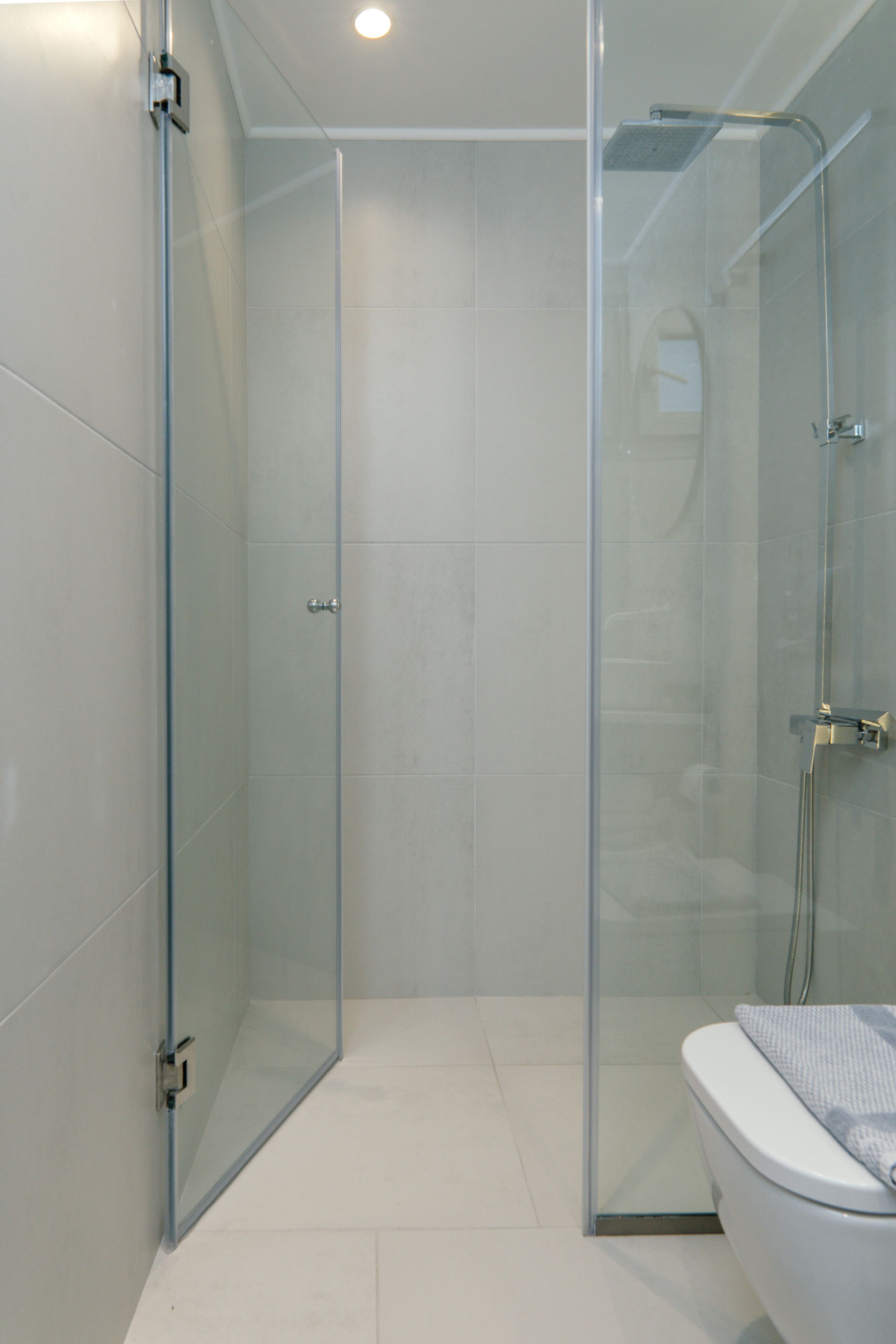 Une salle de bain moderne avec une douche à parois de verre, des toilettes et un lavabo.