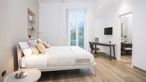 A modern bedroom with a bed, bedside table, and a desk with a chair. - AmbroSea Amalfi Coast (Vietri sul Mare)