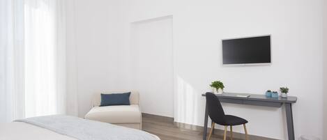 Un dormitorio moderno con una cama, un escritorio y una silla.