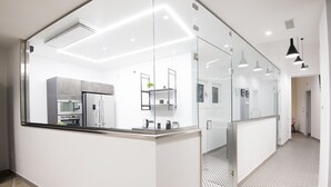 A modern kitchen with a central island, glass partitions, and pendant lighting. - AmbroSea Amalfi Coast (Vietri sul Mare)