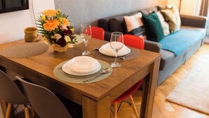 Une table à manger dressée avec des assiettes, des verres et un vase de fleurs.