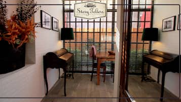 Relax in a cozy seating area with a wooden bench and table, surrounded by a brick wall and wooden floor.