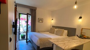 A bedroom with a bed, a desk, and two stools. - Storytellers Villas (Sintra)