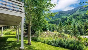 A covered outdoor area with a view of a lush green valley and forested mountains. - Nice Home in Great Vail Location! Hot Tub, Free Shuttle Access!! (Vail)