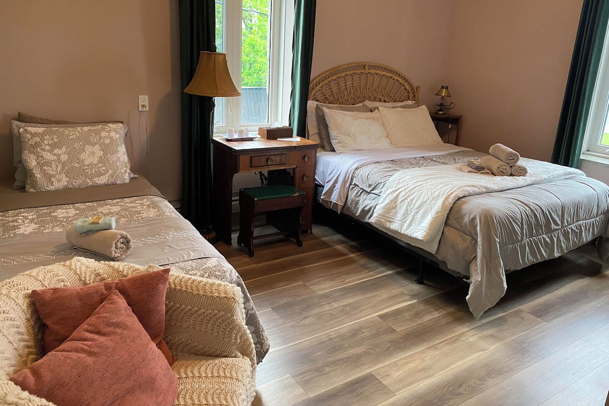 Ein Hotelzimmer mit zwei Betten, einem Schreibtisch und einem Stuhl.