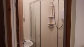 A bathroom with a shower, a sink, and a toilet. - The Hotel Fame (Blackpool)