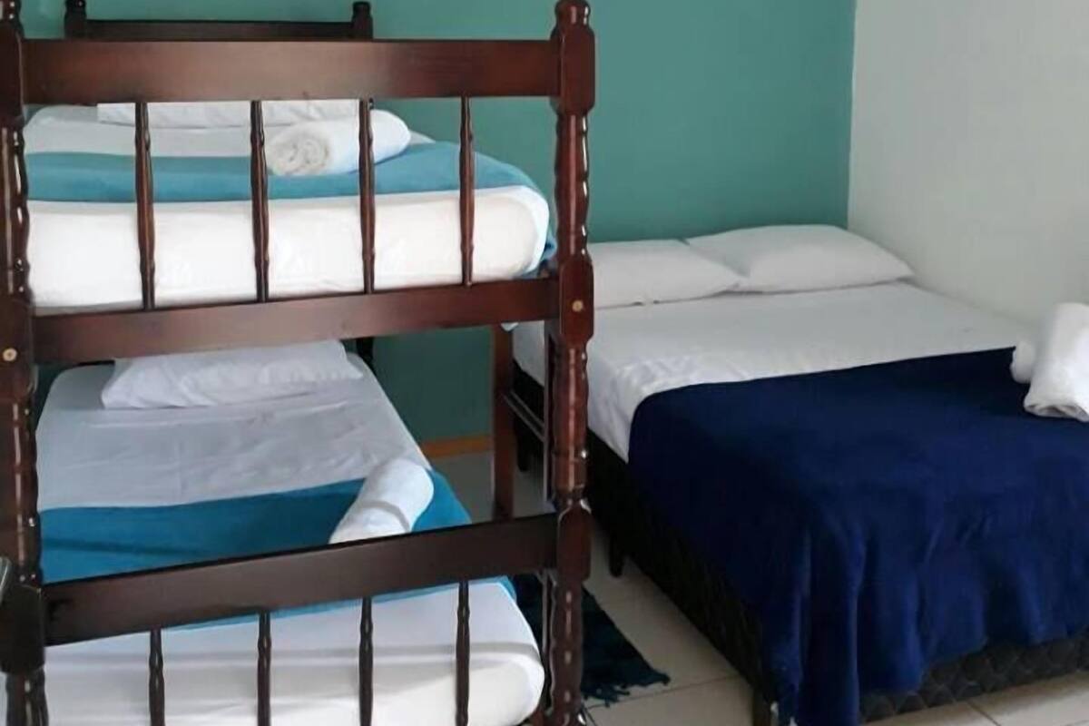 Une chambre avec deux lits, dont l’un est doté d’une tête de lit en bois et l’autre d’une tête de lit simple.
