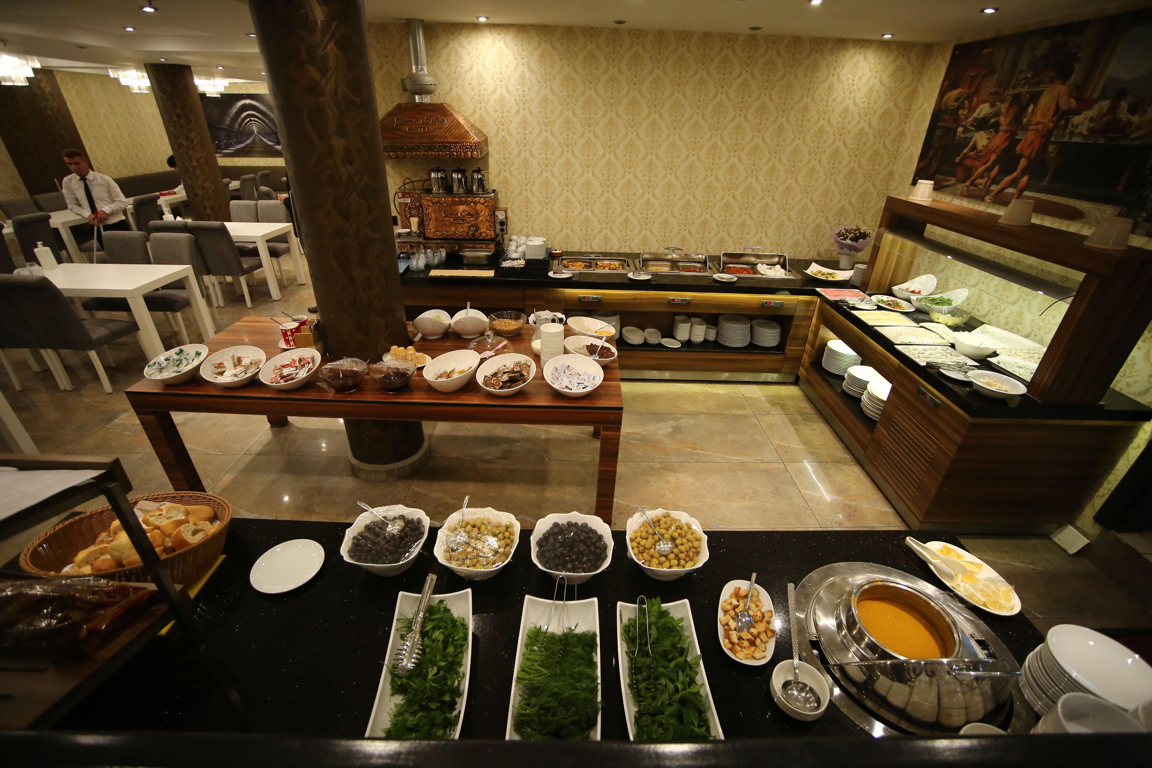 A buffet setup with various food items and a coffee station.