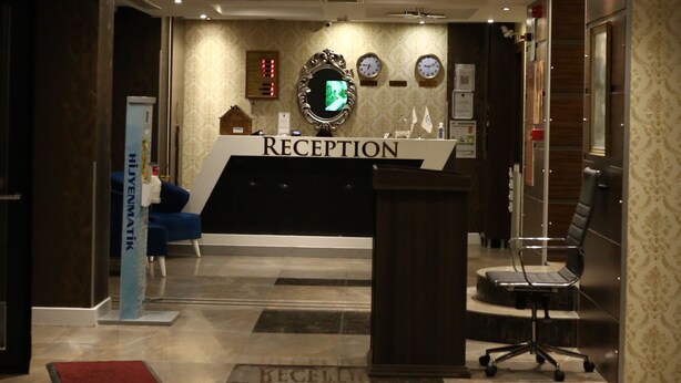 Un'area reception con una scrivania, un orologio e un display a parete.