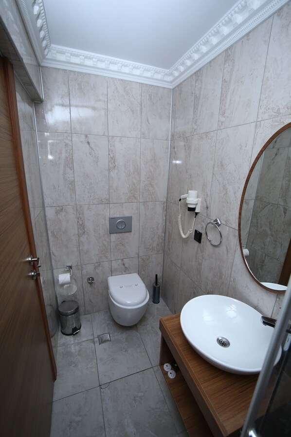 Un baño con inodoro, lavabo y espejo.