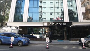 Un hotel moderno con una grande facciata vetrata che riflette gli edifici circostanti.