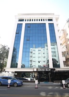 A modern hotel with a large glass facade reflecting nearby buildings.