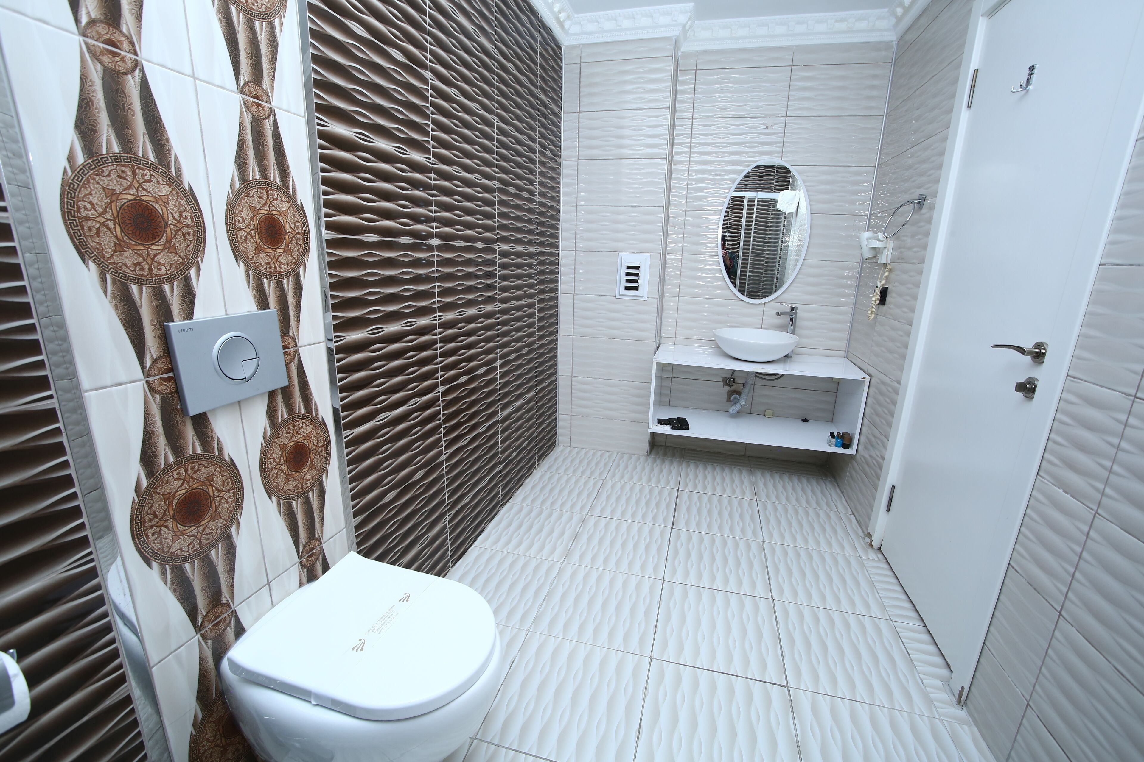Een moderne badkamer met toilet, wastafel en spiegel.