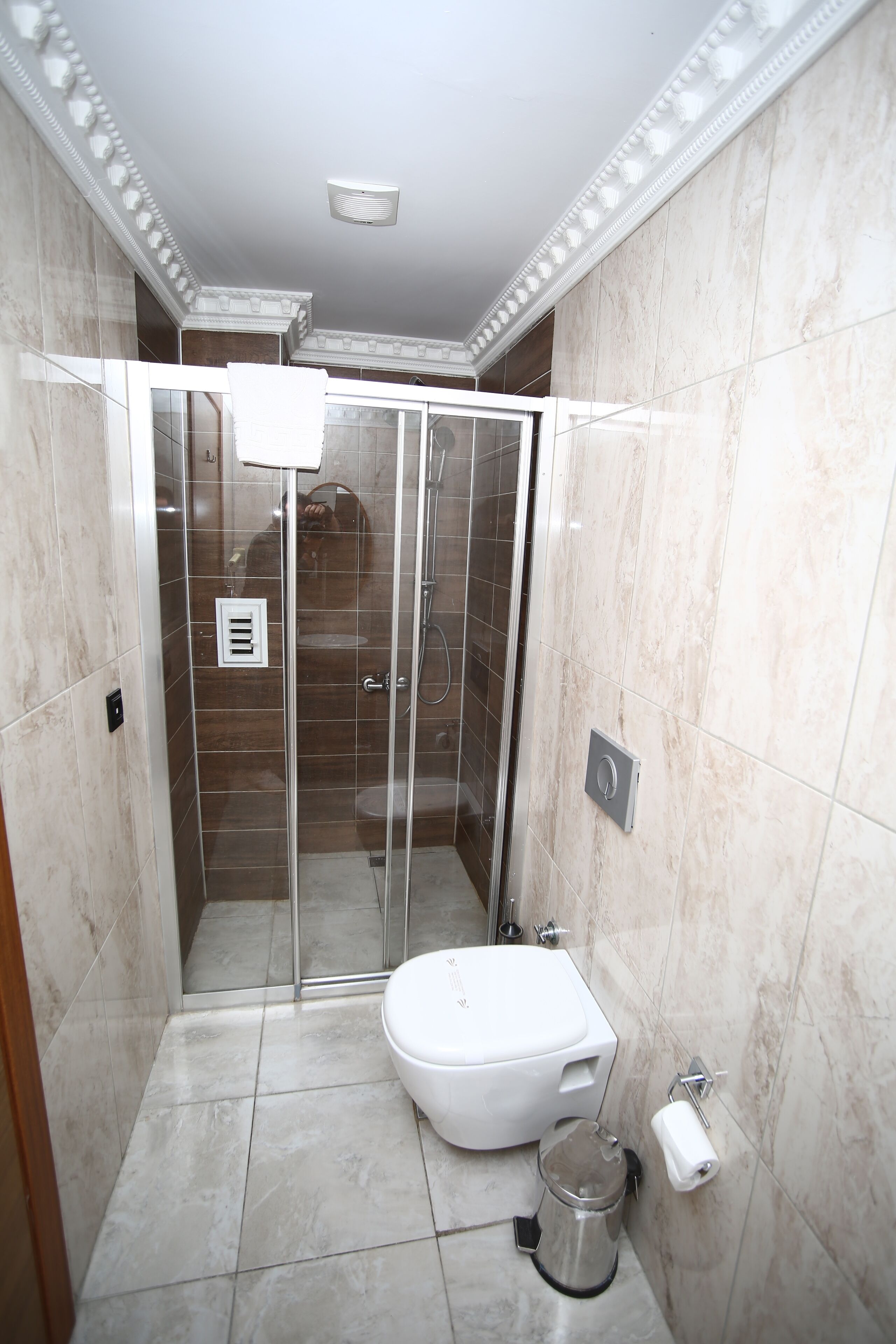 Een badkamer met een douchecabine, een toilet en een wastafel.