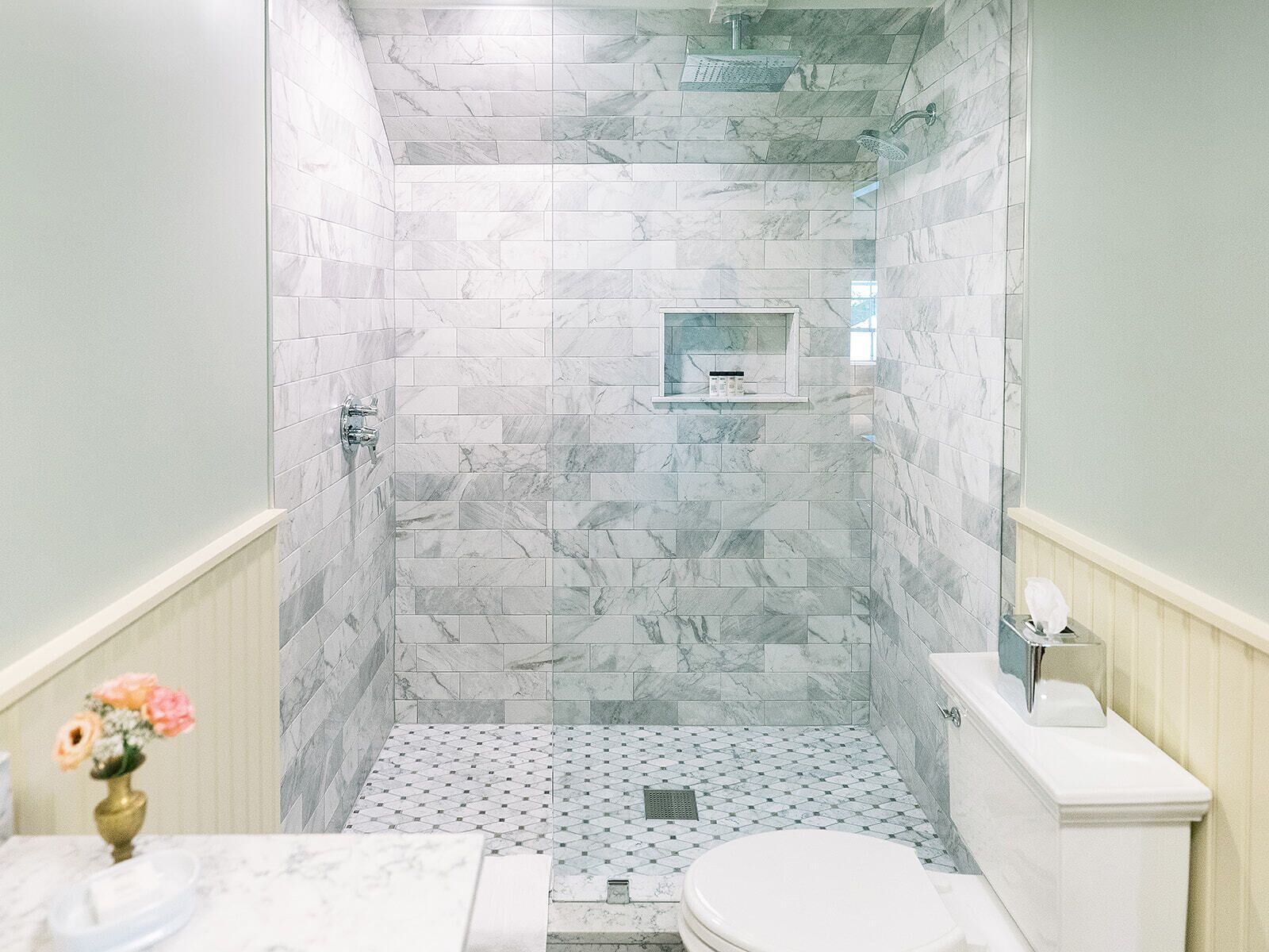A bathroom with a shower, toilet, and sink.