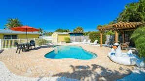 A backyard with a swimming pool, a wooden pergola, and outdoor furniture. - AMI North End Private Heated Pool.  1.2 Block to Gulf Beach! (Anna Maria)