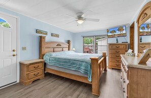 A bedroom with a wooden bed, a nightstand, a dresser, a ceiling fan, and a TV mounted on the wall. - SLEEPS 10!  3 bedrms/3 baths/Pier House. One Golf Cart incl. 2nd Cart available (Garden City)