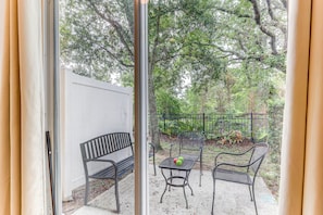 Enjoy a peaceful retreat with a patio view of lush greenery and a seating area.