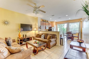 Relax in the living room with a sofa set, flat-screen TV, and dining table.