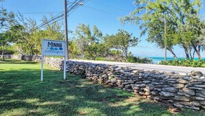 A sign for 'Minns Cottages' with a stone wall and greenery in the foreground.