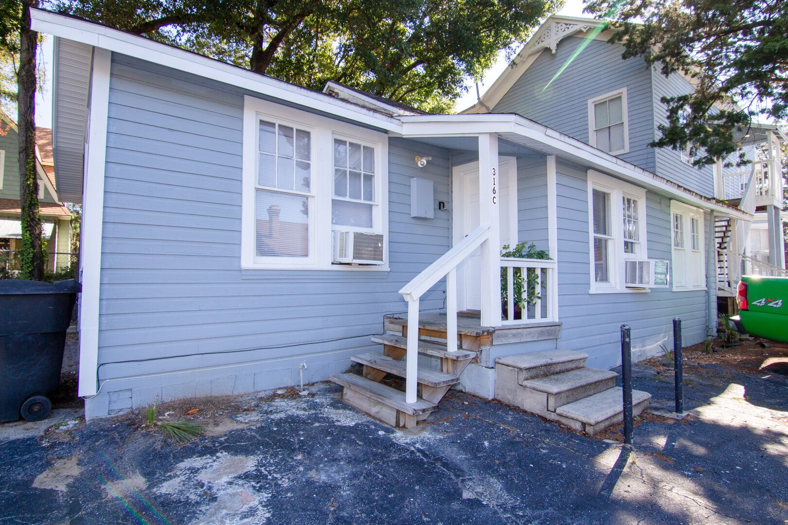 A single-story house with a front porch and a small staircase leading to the entrance.