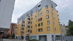 A multi-story building with a yellow and grey facade, featuring balconies and large windows. - Anita Tour As / Central 1BR App, free garage, AC, Wi-Fi, 7min walk from old town (Ljubljana)