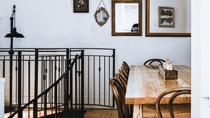 A dining area with a wooden table and chairs, a chandelier, and various framed pictures on the wall. - Corvah House, Beautiful Corvah House circa 1860, restored and beaming with grandeur and comfort (Castlemaine)