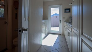 A hallway with a door leading to a balcony with a mountain view. - Piazza Rocca - private acre w/Pool, hot tub, 270 degree mountain views! (Tucson)