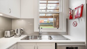 Een moderne keuken met een roestvrijstalen spoelbak, een broodrooster en een koffieapparaat.