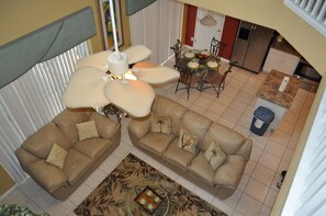 Ein geräumiger Wohnbereich mit zwei Sofas, einem Couchtisch und einem Esstisch mit Stühlen.