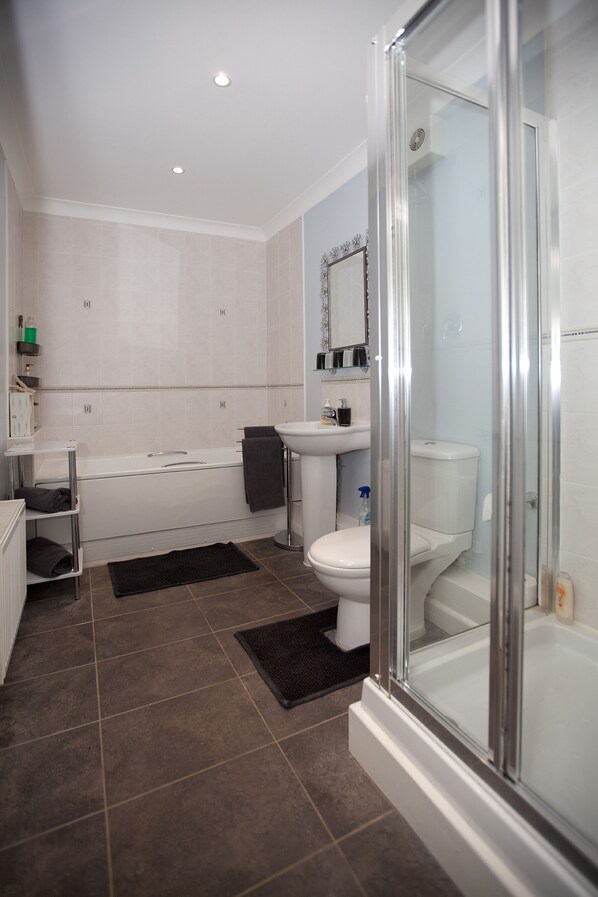 Une salle de bain moderne équipée d’une baignoire, de toilettes et d’un lavabo.