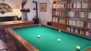 A billiards table with balls, a bookshelf with books, and a fan on the wall. - HILLTOP APARTMENT WITH GREAT WIEW BETWEEN SIENA AND VOLTERRA (Casole D'Elsa)