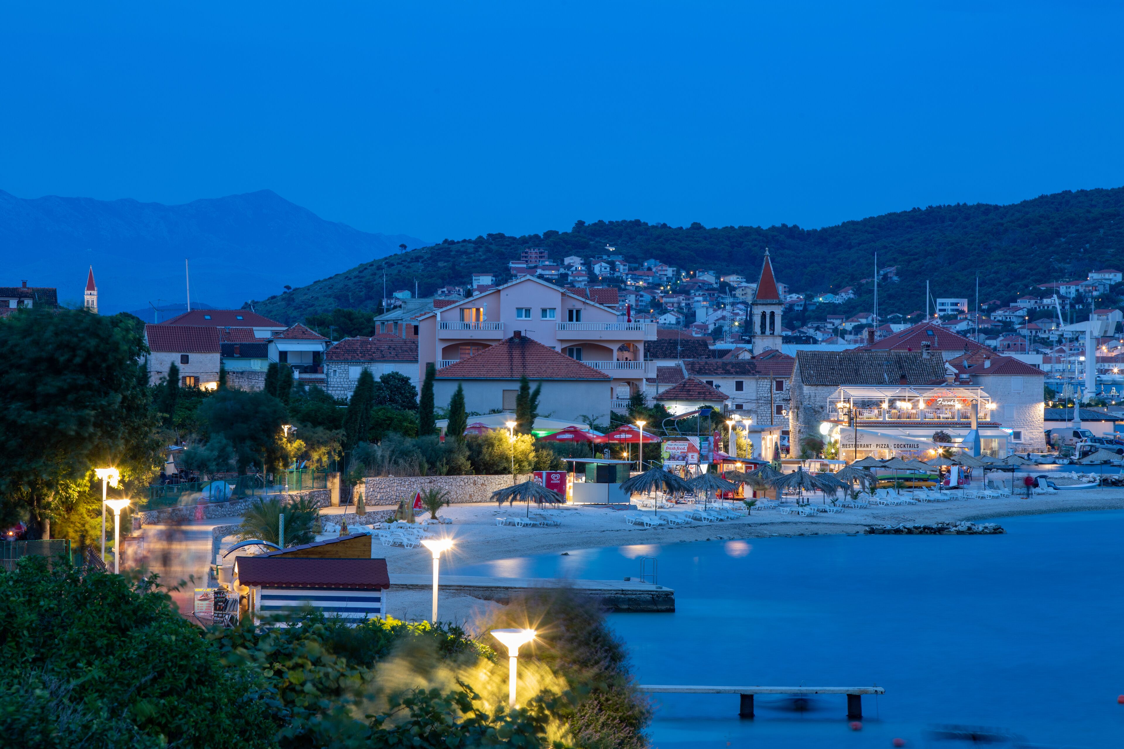 A coastal town with a beach, waterfront buildings, and a prominent church.