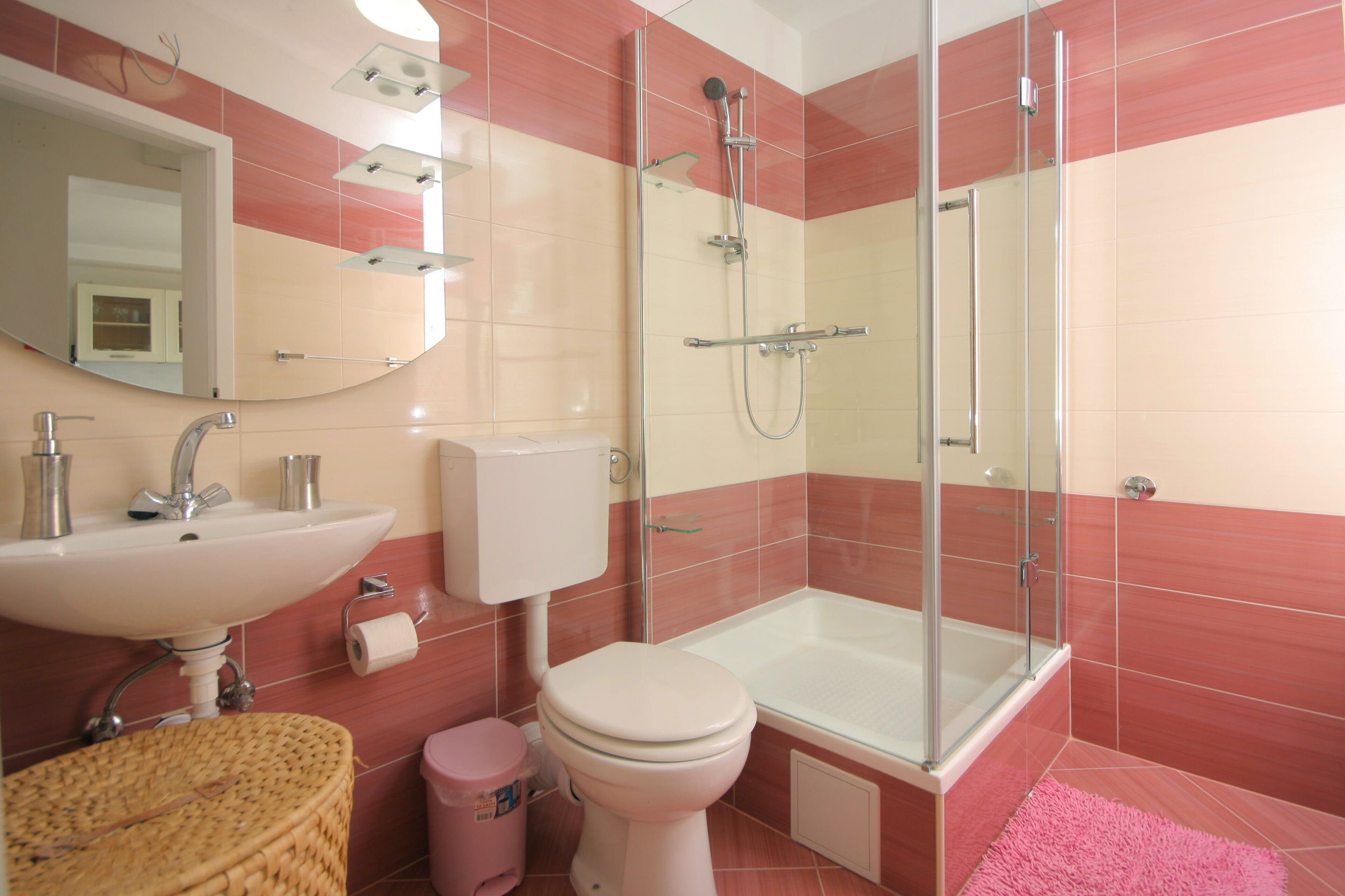 A bathroom with a sink, toilet, and shower area.