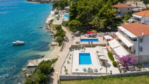A coastal hotel with a swimming pool, beach access, and a view of the sea.