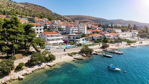 A coastal town with a marina, clear blue waters, and buildings with red-tiled roofs.