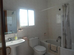 Bañera con ducha, bidet, toallas, jabón