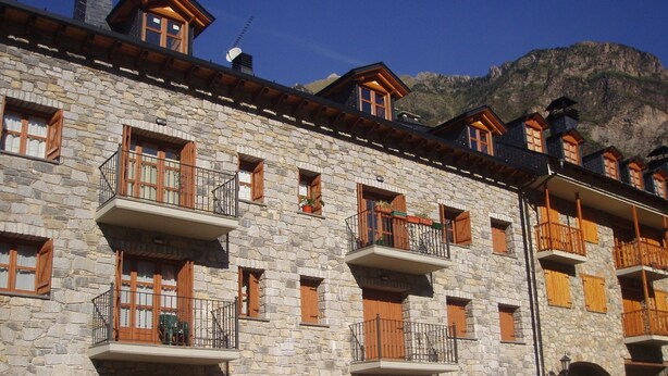 Un edificio de piedra con varios balcones y puertas arqueadas.