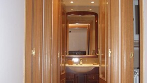 Un pasillo que conduce a un baño con marco de puerta de madera, un lavamanos y armarios.
