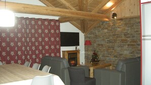 Ein Essbereich mit Holztisch und -stühlen, einem Kamin und einer Steinwand.