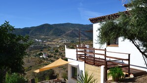 A white building with a wooden balcony and a view of a mountainous landscape. - The African House, rural getaway between Ronda and Málaga (Tolox)