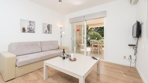 Un salon moderne avec un canapé, une table basse et des œuvres d’art accrochées au mur.