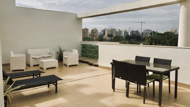 A rooftop terrace with a seating area, including a table and chairs, and a sofa. - Beautiful duplex apartment with pool 200 meters from the beach and golf (el campello muchavista)