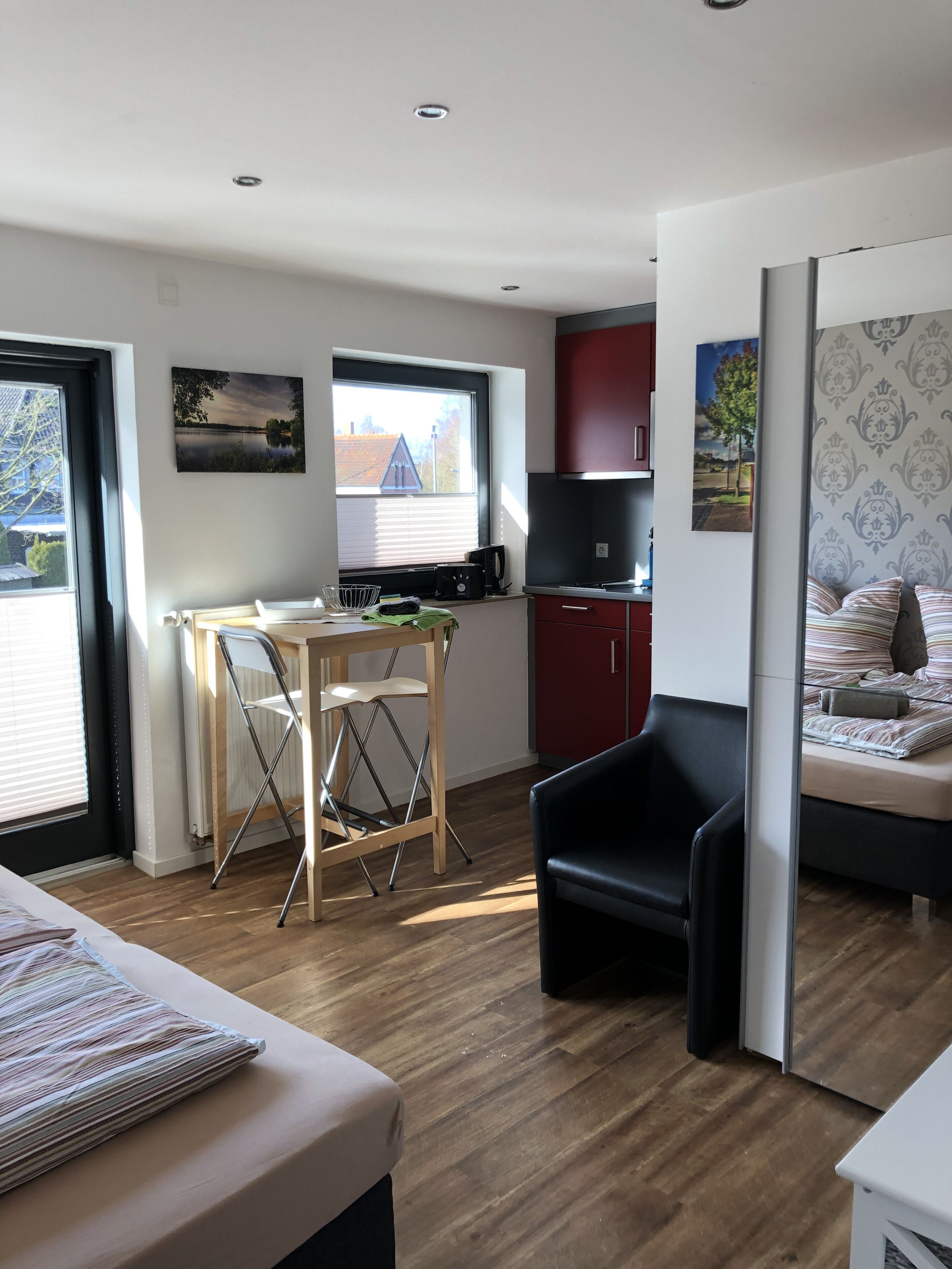 A compact living space with a kitchenette, a dining area, and a bedroom.