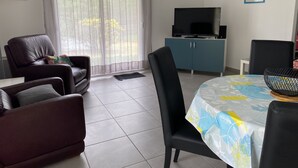 Olohuone, jossa on televisio, ruokapöytä ja sohva.
