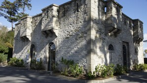 Un bâtiment en pierre doté de fenêtres en arc de cercle et d’une entrée centrale.