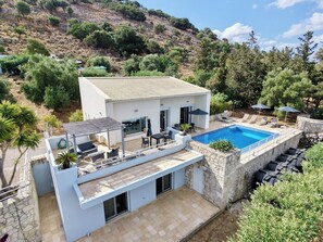 A modern two-story house with a swimming pool, outdoor seating, and a view of the surrounding landscape. - Modern villa for 1 to 6 people, private pool, beautiful sea and mountain views (Crete)