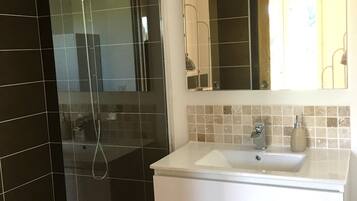 Een bad/douchecombinatie, een haardroger, handdoeken, toiletpapier