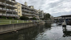 Een gracht met een rij meerverdiepingen aan één kant, voorzien van balkons en een brug over het water.